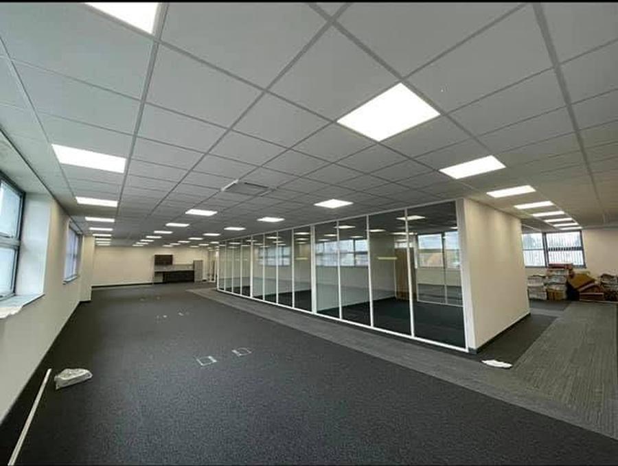 Open-plan office with suspended ceiling grid and glazed partitioning