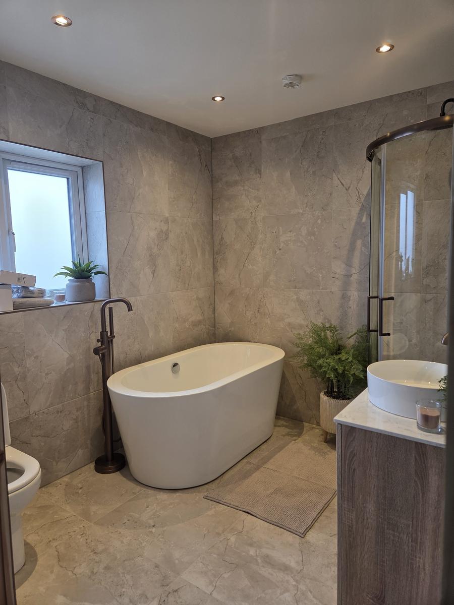 Family bathroom renovation with freestanding bath and recessed ceiling lighting